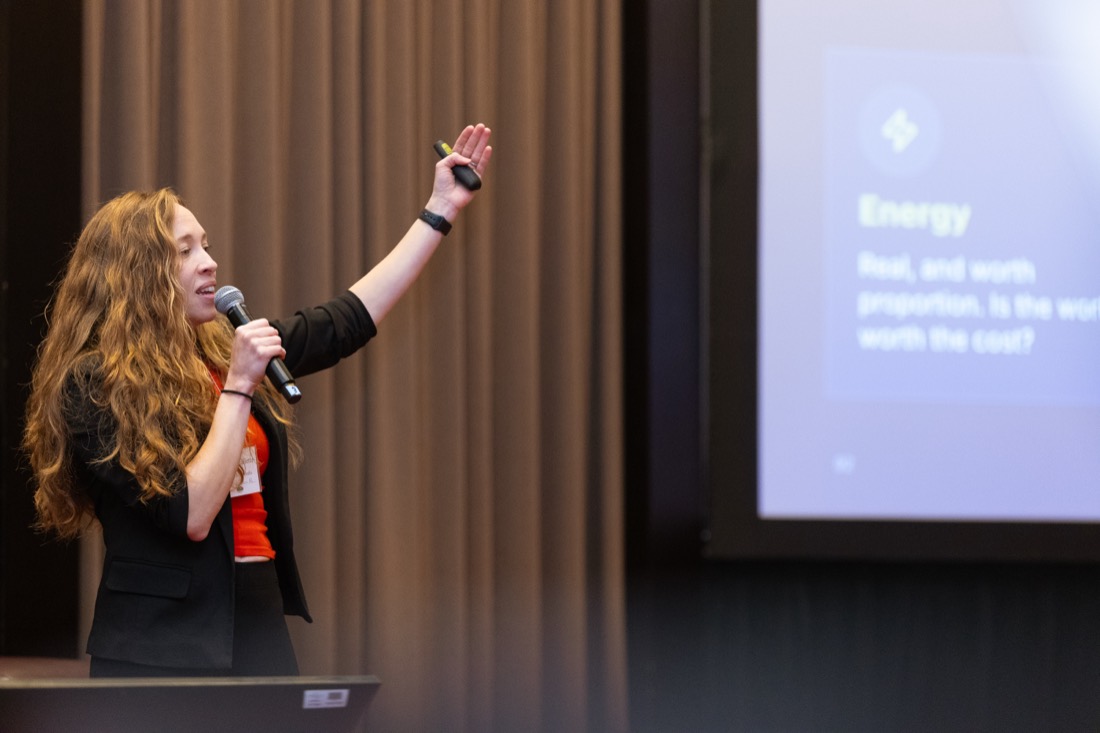 Teryl Brouillette gesturing toward the audience beside a slide about energy