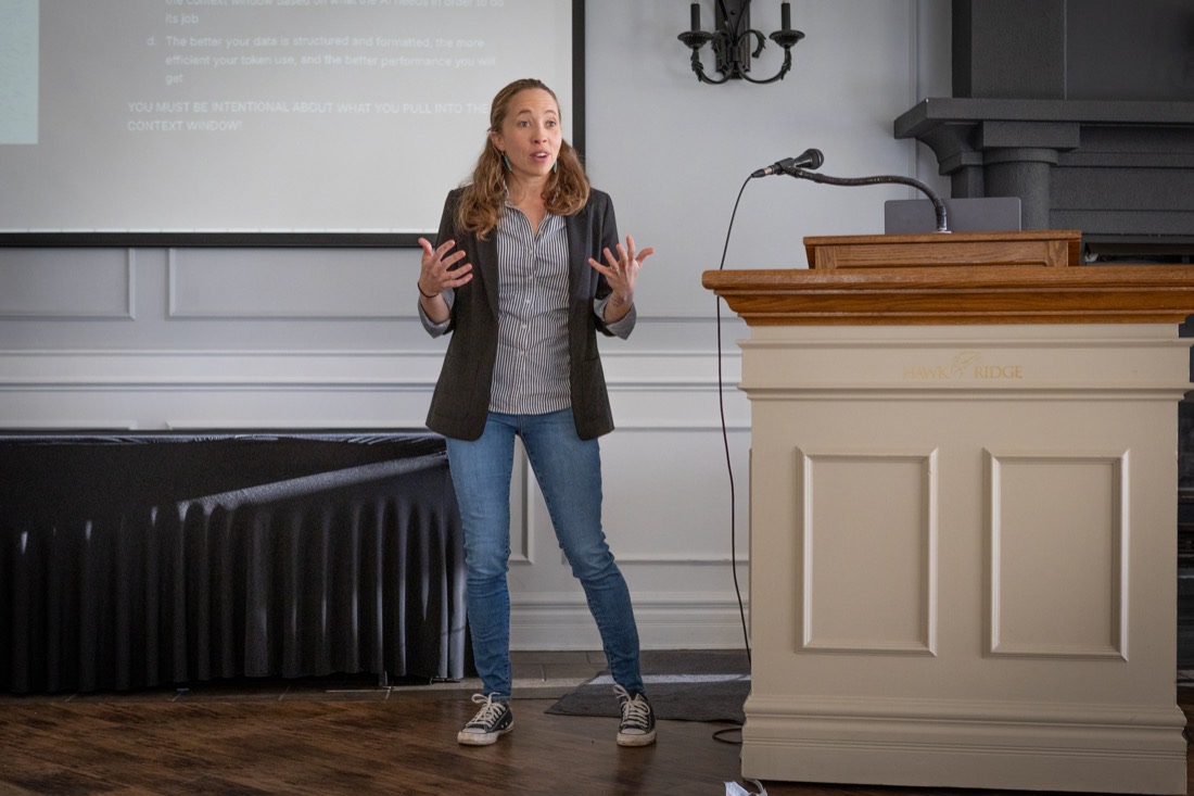 Teryl Brouillette speaking beside the podium at a custom GPT workshop