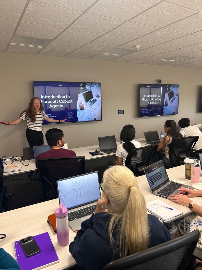 Teryl Brouillette presenting an Introduction to Microsoft Copilot Agents slide to a room of participants at laptops