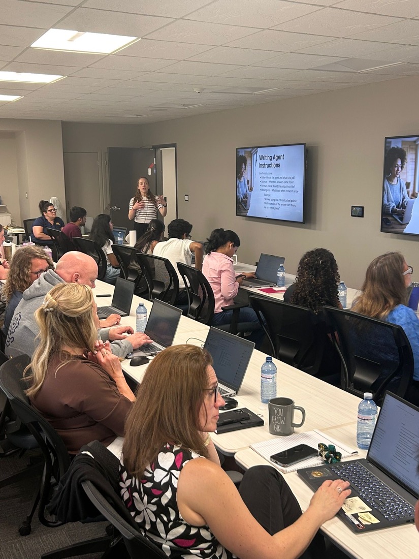 Workshop participants at laptops following a slide on writing agent instructions
